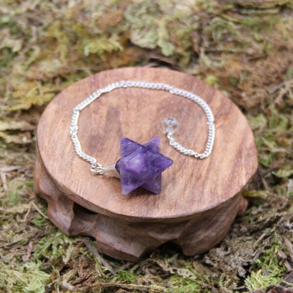 Un pendule en améthyste de forme Merkaba, parfait pour la divination et la méditation, grâce à ses propriétés énergétiques et à son design symbolique.