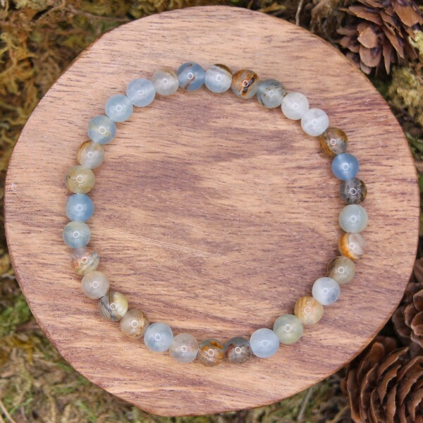 Ce bracelet en perles de calcite bleue est une pièce élégante et apaisante, certifiée authentique, idéale pour ceux qui cherchent à renforcer leur sérénité et leur bien-être intérieur. Cette pierre est particulièrement recommandée pour apaiser les émotions négatives, réduire le stress et favoriser un état de calme profond. Elle aide également à clarifier les pensées, offrant une meilleure communication, tout en favorisant la guérison émotionnelle et la relaxation.