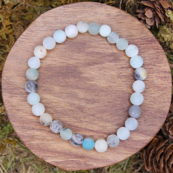 Les perles de ce bracelet, mates et certifiées authentiques, présentent des nuances variées allant du vert pâle au bleu profond, parfois teintées de beige ou de brun. Cette diversité de couleurs en fait un accessoire unique et naturel, s’adaptant à tous les styles. En plus de ses qualités esthétiques, l’Amazonite est réputée pour renforcer la communication et la positivité, aidant à mieux exprimer ses émotions et ses pensées.