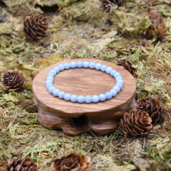 L'Angélite est une pierre précieuse aux teintes bleu clair à bleu pâle, appartenant à la famille des sulfates. Son nom provient du terme "angélique" en raison de ses propriétés apaisantes et spirituelles.