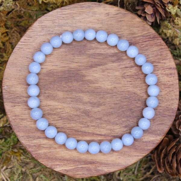 Ce bracelet en perles d' Angélite est fabriqué avec des perles mates certifiées authentiques. Il est conçu pour accompagner ceux qui recherchent sérénité et équilibre dans leur vie quotidienne. En le portant, vous bénéficierez des vertus de cette pierre pour apaiser l’esprit, améliorer la communication et renforcer votre harmonie intérieure.