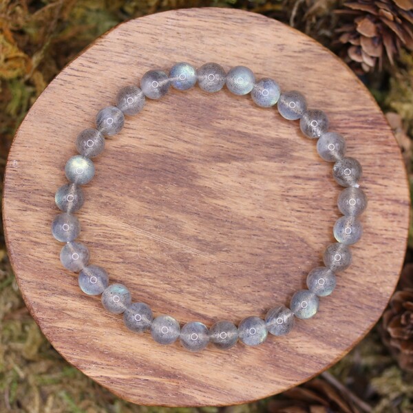 Ce bracelet se distingue non seulement par son esthétique unique, mais aussi par les vertus spirituelles qu'il apporte. La labradorite est largement reconnue pour ses propriétés de bien-être et de protection, agissant comme un bouclier contre le stress, l'anxiété et la tristesse. Elle est souvent utilisée pour renforcer l'aura de son porteur et favoriser l'harmonie émotionnelle.