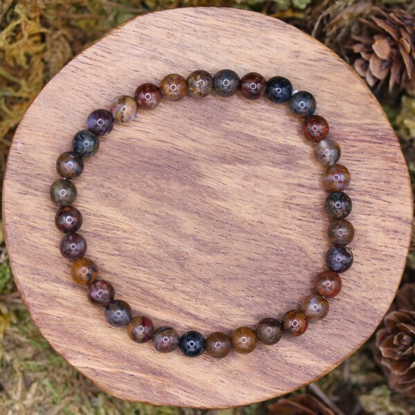 Bracelet en perles de Pietersite certifiées authentiques. Chaque perle est minutieusement sélectionnée pour sa beauté et ses propriétés énergétiques. Ce bracelet est idéal pour ceux qui cherchent à se connecter à leur force intérieure et à leur capacité de transformation. Porté régulièrement, il peut aider à renforcer la confiance en soi et à stimuler la créativité tout en apportant une protection spirituelle.