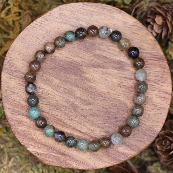 Le bracelet en perles de serpentine est une création naturelle au charme authentique. Cette pierre, d’un vert profond parfois ponctué de nuances jaunes ou grises, est connue depuis l’Antiquité pour ses vertus de purification et de connexion à la Terre. Elle est prisée en lithothérapie pour ses effets équilibrants sur les émotions et pour sa capacité à absorber les énergies négatives, créant une sensation de calme et de recentrage. La serpentine accompagne ainsi les personnes en quête de sérénité, les aidant à retrouver un ancrage solide face aux turbulences de la vie.