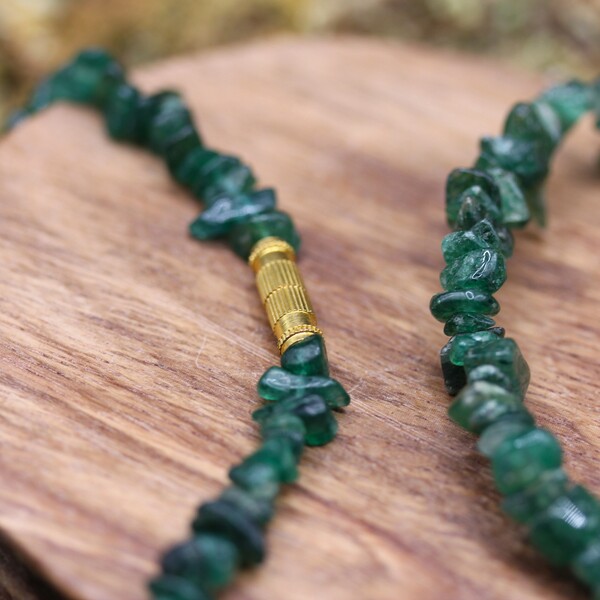 Cette parure en jade vert, composée d’un collier et d’un bracelet en galets concassés, offre prospérité, harmonie et bien-être. Un bijou purificateur et protecteur.