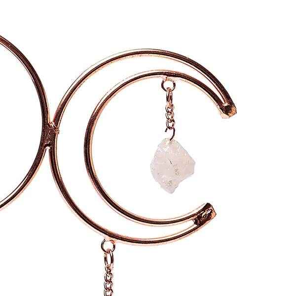 Gros plan sur les pierres naturelles améthyste, quartz rose et cristal de roche montées sur une suspension en cuivre