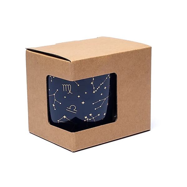 Gros plan sur une tasse astrologique Bone China avec design céleste et infuseur intégré.